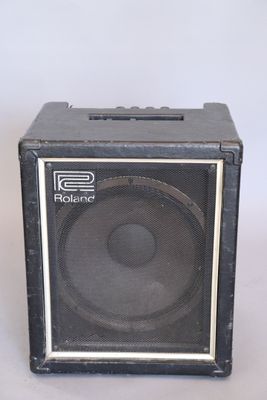 an old black speaker sitting on top of a white table