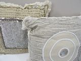 two pillows and a purse sitting on a table