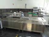 a large stainless steel kitchen with a sink and dishwasher