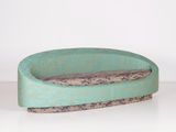 un petit bol vert bordé de marron, posé sur une table blanche
