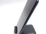 a cell phone on a stand on a white surface