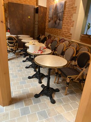 tables and chairs are lined up in a restaurant with brick walls