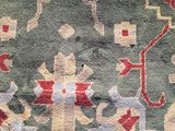 an image of a green and red rug with a design on it