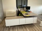 a desk with a computer on top of it in a room