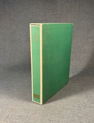 an old green book sitting on top of a gray surface