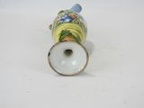 a small vase with a bird on it on a white surface