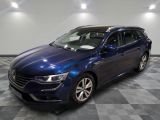 une voiture bleue est garée sur le sol à carreaux d'un garage