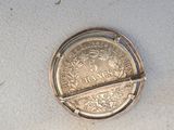 a silver coin that is laying on a white surface