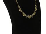 a close up of a necklace on a mannequin with a white background