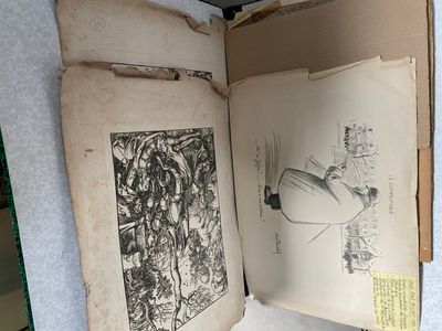 an open book with drawings on it sitting on a table