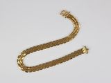 a gold chain bracelet with a clasp on a white surface