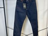 Les jeans sont suspendus à un portant dans la pièce.
