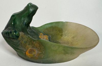 un bol vert orné d'une grenouille, posé sur un fond blanc