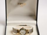 a gold watch in a box with a white background