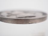 a close up of a silver coin on a table