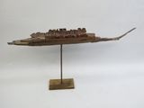 une vieille maquette de bateau en bois posée sur un socle en bois