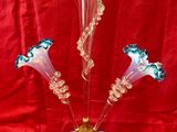 a glass vase with flowers in it on a red cloth