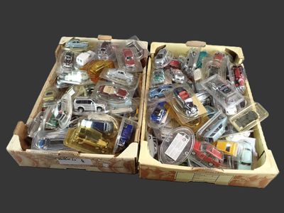 deux boîtes remplies de petites voitures de toutes sortes posées sur une table