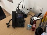 a desk with a phone, a book, and other office supplies on it