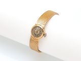 une image représentant une montre-bracelet posée sur une serviette de table, elle-même posée sur une surface blanche