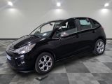 la petite voiture noire est garée dans le garage sur un sol en damier