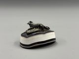 une photo représentant une sculpture d'un chien assis sur un livre