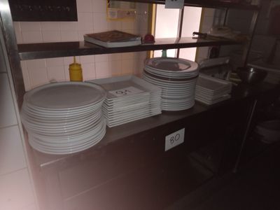 Plusieurs assiettes sont empilées sur une étagère dans une cuisine