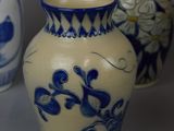 three blue and white vases are sitting on a gray surface