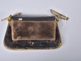 an old purse with a metal handle on a white surface
