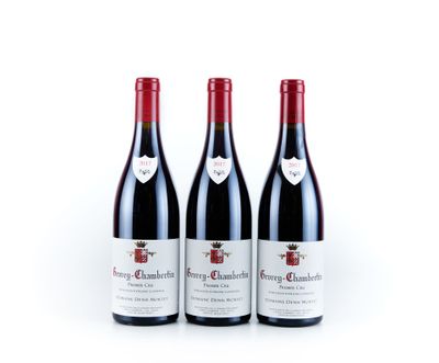 trois bouteilles de vin rouge posées l'une à côté de l'autre sur une surface blanche