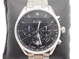 la montre est posée sur un coussin, sur une surface blanche