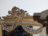 a mirror that is sitting on a shelf with a clock on it