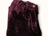 the purple sweater is laying on top of a white surface