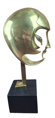 brass sculpture of a man ' s face on a black base