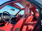 l'intérieur d'une voiture avec des sièges en cuir rouge et un volant