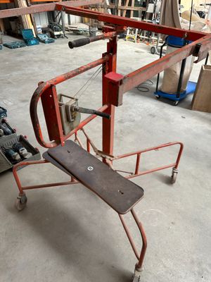 un petit chariot rouge avec un skateboard dessus, dans un garage
