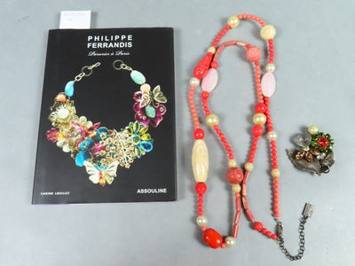 un livre et un collier posés sur une table à côté d'un livre