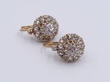 a pair of diamond earrings on a white surface