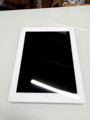 un iPad posé sur une table blanche, dont l'écran est noir