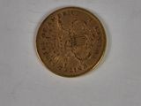 a gold coin on a white surface with a white background