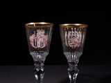 two wine glasses sitting on top of a table next to each other
