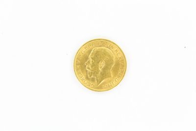 gros plan d'une pièce d'or sur une surface blanche