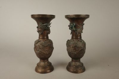 deux vases en bronze posés l'un à côté de l'autre sur une table