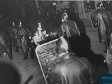 une vieille photo en noir et blanc montrant un groupe de personnes rassemblées autour d'un sapin de Noël