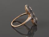 a close up of a gold and diamond ring on a reflective surface