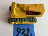 un petit bulldozer jaune en jouet sur une feuille de papier bleue