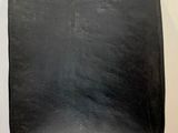 a black chair sitting on a wooden floor next to a white wall
