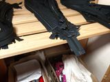 three pairs of black zippers on a wooden shelf