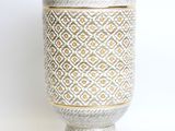 a white vase with a pattern on it on a table