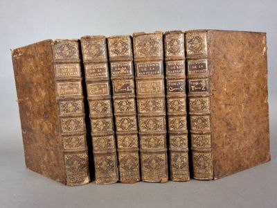 six vieux livres empilés les uns sur les autres sur une table